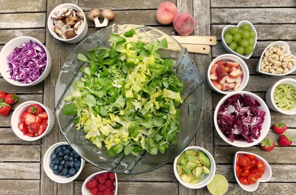 Salad in bowl with many ingredients draped around in small bowls
